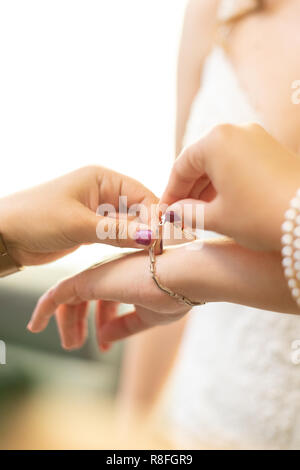 Frau Hände helfen, ein Armband, eine Braut zu setzen Stockfoto