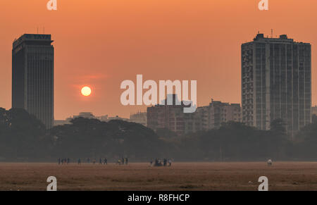 Indische Hirten mit ihren inländischen Ziegen auf dem Maidan Boden mit Blick auf die Hochhäuser in Kalkutta, Indien. Stockfoto