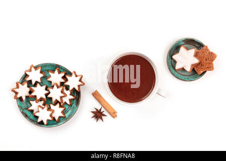 Ein Foto von Zimtsterne, traditionelle Weihnachten Zimt Stern cookies, Schuß von oben auf einen weißen Hintergrund mit heißer Schokolade und Gewürze Stockfoto