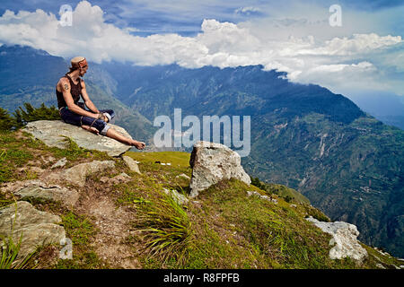 Naggar, Indien - August 2017. Mann sitzt auf Berggipfel und blickt auf die Kullu Tal. Naggar, Himachal Pradesh. Nord Indien. Stockfoto