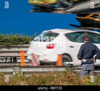 Polizeioffizier mit Geschwindigkeit Kamera überwacht die Geschwindigkeit von Fahrzeugen am Rande der Autobahn Stockfoto