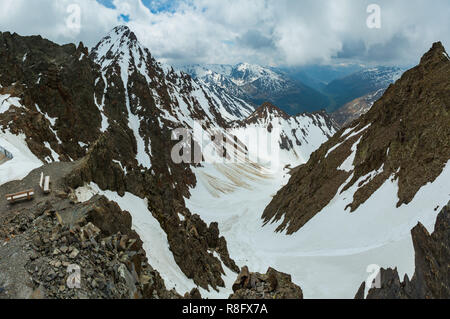 Juni Blick von der Karlesjoch Alpen Berg (3108 m, in der Nähe der Kaunertal Gletscher auf Austria-Italy Grenze) über den Abgrund und Wolken. Stockfoto