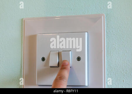Nahaufnahme der einen Finger drehen auf einem Lichtschalter Stockfoto