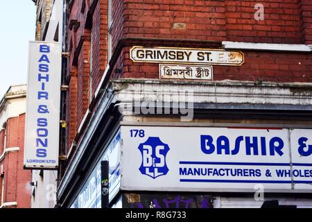 Grimsby Straße, Brick Lane, East London, mit einem Straßennamen in Englisch an der Oberseite und in Bengali an der Unterseite Stockfoto