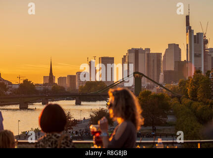 Die Leute trinken Cocktails vor der Skyline von Frankfurt am Main. Stockfoto