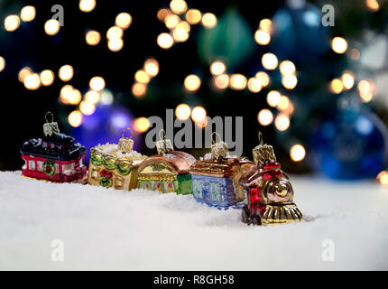 Weihnachtsschmuck im Schnee mit funkelnden Lichter im Hintergrund Stockfoto