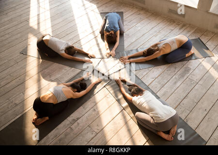 Fünf junge Frauen tun Kind darstellen, während Yoga Session Stockfoto