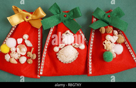 Weihnachten Handwerk Konzept. Do it yourself Handarbeit Filz Geschenkbeutel mit Muscheln und Perlen dekoriert Stockfoto