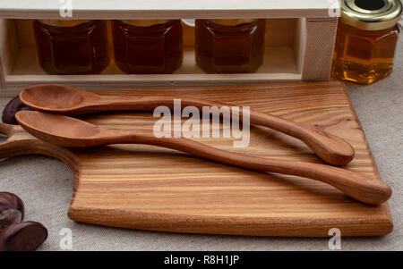 Honig in verschiedenen Sorten in kleinen Gläsern, mit hölzernen Küchengeräte. Stockfoto