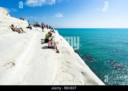 Touristen im Scala dei Turchi genießen einen schönen Blick auf das türkisfarbene Wasser des Mittelmeers, Realmonte, Provinz Agrigento, Sizilien, Italien Stockfoto