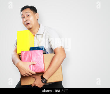 Foto Portrait von einem netten gutaussehenden jungen asiatischen Kurier Mann glücklich lächelnd, während sie viele Geschenkbox Paket Stockfoto