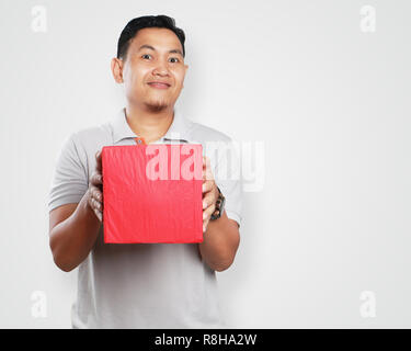 Foto Bild Portrait einer niedlichen hübscher junger asiatischer Mann lächelnd, während sie roter Geschenkbox Paket Stockfoto