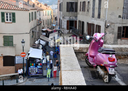 Rund um Korsika - EIN Pink Scooter parkte mit Blick auf eine Hauptstraße in Calvi Stockfoto