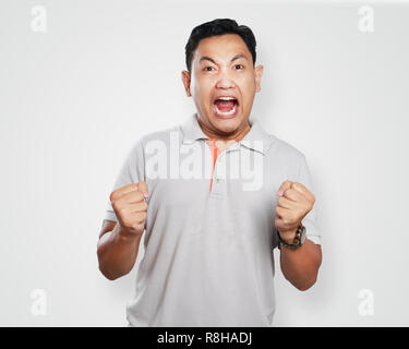 Foto Portrait von einem netten gutaussehenden jungen asiatischen Menschen schreien Zorn zu lösen, mit seinen Fäusten bereit zu lochen Stockfoto