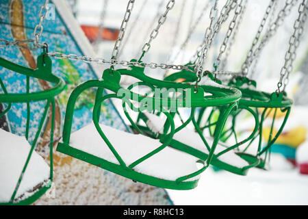 Nahaufnahme eines Swing Chair in einem Karneval mit Schnee bedeckt. Swing Stühle im Winter Tag. Stockfoto