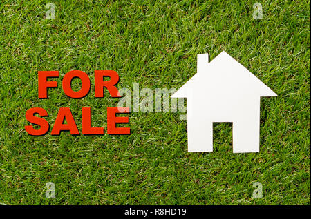 Konzeptionelle Bild des Weißen Hauses und Text für Verkauf auf grünem Gras Feld oben Ansehen und Kopieren in Property Investment Immobilien speichern und b geschrieben Stockfoto