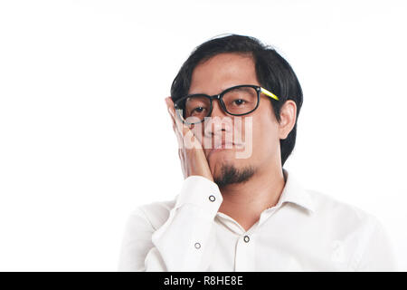 Foto Bild Portrait einer Lustig junge asiatische Geschäftsmann mit Brille sah sehr gelangweilt oder Zahnschmerzen, Nahaufnahme, Porträt, trauriges Gesicht mit Stockfoto