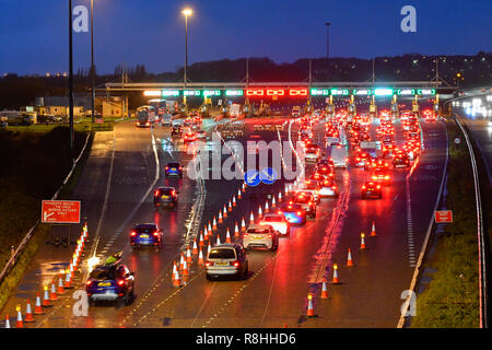 Severn Bridge, Wales, UK. 15. Dezember 2018. Verkehr Queuing bei Dämmerung für die Maut als Arbeit weiter zu entfernen drei der Severn Bridge Mautstellen auf der Autobahn M4 in Wales, UK vor der Maut ab Montag, den 17. Dezember verschrottet werden, wenn es gratis ist, die Brücke zu überqueren. Foto: Graham Jagd-/Alamy leben Nachrichten Stockfoto