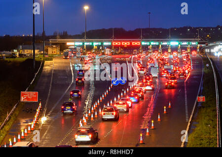 Severn Bridge, Wales, UK. 15. Dezember 2018. Verkehr Queuing bei Dämmerung für die Maut als Arbeit weiter zu entfernen drei der Severn Bridge Mautstellen auf der Autobahn M4 in Wales, UK vor der Maut ab Montag, den 17. Dezember verschrottet werden, wenn es gratis ist, die Brücke zu überqueren. Foto: Graham Jagd-/Alamy leben Nachrichten Stockfoto