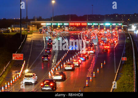 Severn Bridge, Wales, UK. 15. Dezember 2018. Verkehr Queuing bei Dämmerung für die Maut als Arbeit weiter zu entfernen drei der Severn Bridge Mautstellen auf der Autobahn M4 in Wales, UK vor der Maut ab Montag, den 17. Dezember verschrottet werden, wenn es gratis ist, die Brücke zu überqueren. Foto: Graham Jagd-/Alamy leben Nachrichten Stockfoto