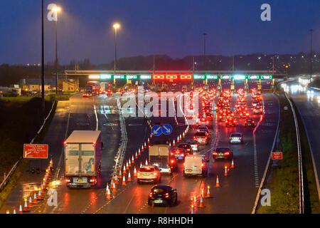 Severn Bridge, Wales, UK. 15. Dezember 2018. Verkehr Queuing bei Dämmerung für die Maut als Arbeit weiter zu entfernen drei der Severn Bridge Mautstellen auf der Autobahn M4 in Wales, UK vor der Maut ab Montag, den 17. Dezember verschrottet werden, wenn es gratis ist, die Brücke zu überqueren. Foto: Graham Jagd-/Alamy leben Nachrichten Stockfoto