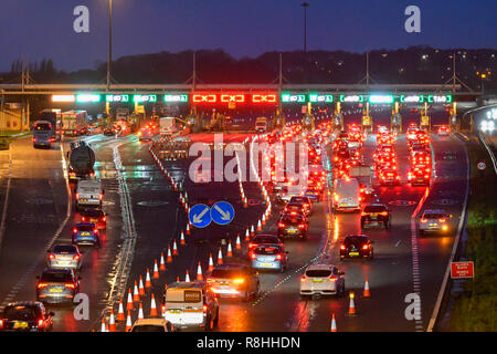 Severn Bridge, Wales, UK. 15. Dezember 2018. Verkehr Queuing bei Dämmerung für die Maut als Arbeit weiter zu entfernen drei der Severn Bridge Mautstellen auf der Autobahn M4 in Wales, UK vor der Maut ab Montag, den 17. Dezember verschrottet werden, wenn es gratis ist, die Brücke zu überqueren. Foto: Graham Jagd-/Alamy leben Nachrichten Stockfoto