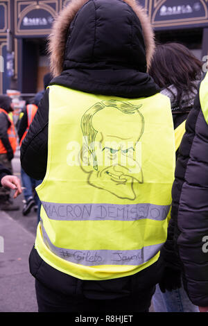 Paris, Frankreich, 15. Dezember, 2018. Stehende Mann trägt eine gelbe Weste mit einer Karikatur des französischen Präsidenten Emmanuel Längestrich und fordern seinen Rücktritt. Rund 2.000 Demonstranten in gelben Westen ('Gilets Jaunes') demonstrierten in Paris gegen Steuererhöhungen und Kaufkraft Verluste für den fünften Samstag in einer Reihe. Credit: Christelle Chanut/Alamy leben Nachrichten Stockfoto