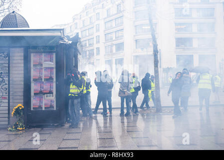 Champs Elysées, Paris, Frankreich. 15. Dez 2018. Demonstranten nehmen die Abdeckung von Wolken von Tränengas von der Polizei erschossen. Gelb (gilets Jaunes) Proteste, Champs-Elysées, Paris, Frankreich, 15. Dezember 2018. Credit: Julien Garnier/Alamy leben Nachrichten Stockfoto