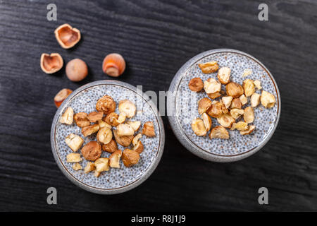 Chia Pudding in ein Glas auf schwarzem Holz- Hintergrund Stockfoto