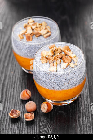 Chia Pudding in ein Glas auf schwarzem Holz- Hintergrund Stockfoto