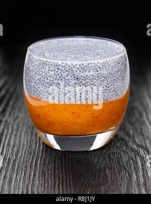 Chia Pudding in ein Glas auf schwarzem Holz- Hintergrund Stockfoto