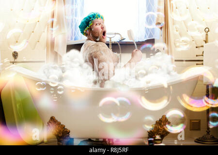 Fetter hässlicher Mann waschen in der Badewanne. Bizarre männliche Person im Bad Stockfoto