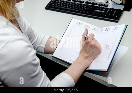 Hand Notizen in Weiß Tagebuch auf dem Tisch Stockfoto