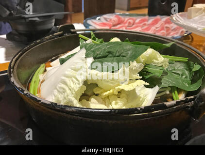 Japanische nabemono hotpot Schüssel dünn geschnittenes Fleisch und Gemüse in Wasser gekocht serviert mit Saucen, bekannt als Shabu-shabu. Kochen Fleisch von Stockfoto