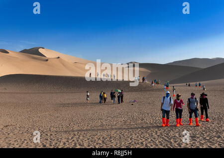 Dunhuang, China - August 8, 2012: Gruppe der chinesischen Touristen im Crescent Moon Lake in der Nähe von Dunhuang in der Provinz Gansu, China. Stockfoto