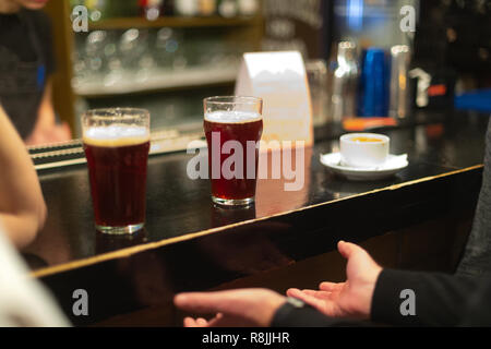Eine Party. Ein Pub. Bar. Club. Ein Restaurant. Biergläser mit dunklem Bier. Dunkle Bier gezapft ins Bier Gläser Stockfoto