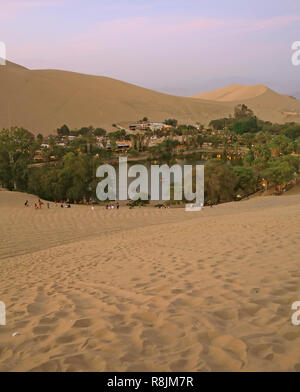 Die Oasenstadt Huacachina von der Sanddüne bei Sonnenuntergang aus gesehen, Region Ica, Peru, Südamerika Stockfoto