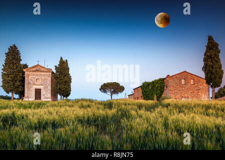 Fantastische fotografie Hotel in der Toskana, berühmt Vitaleta Kapelle im Frühjahr mit spektakulären Vollmond bei Sonnenuntergang, Pienza, Toskana, Italien, Europa Stockfoto