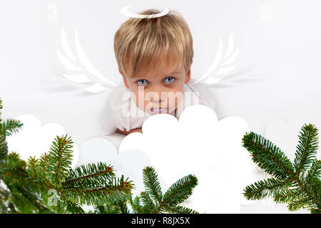 Frech oder gutes Kind zu Weihnachten? PF oder Brief an Santa-Claus für Weihnachten. Kind Junge erscheint als eine liebenswerte Engel Teufel Stockfoto
