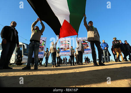 Gaza, Palästina. 14. Dezember 2018 Palästinenser tragen Plakate und eine palästinensische Flagge, wie Sie ein Protest innerhalb der 'Große März erneut auf die Bühne sammeln Stockfoto