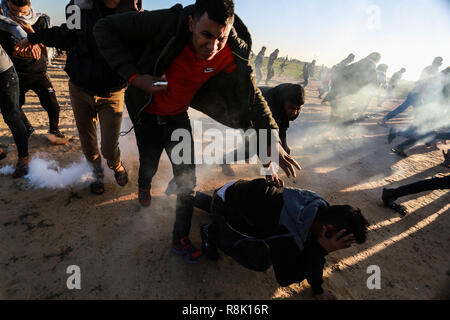 Gaza, Palästina. 14. Dezember 2018 israelische Truppen in den Palästinensischen Demonstranten einmischen, so wie Sie es ein Protest innerhalb der 'Große März zurück Bühne' d Stockfoto