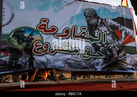 Gaza, Palästina. 14. Dezember 2018 Palästinenser tragen Plakate und eine palästinensische Flagge, wie Sie ein Protest innerhalb der 'Große März erneut auf die Bühne sammeln Stockfoto