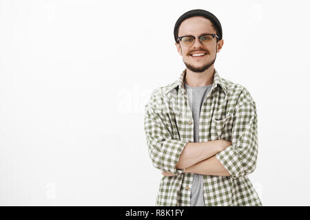 Geschickte und intelligente stattlichen europäischen Mann mit schwarzer Mütze und überprüft grünes T-Shirt lächelnd mit selbstbewussten und Ausdruck breit grinsend zufrieden mit Arbeit erreicht Stockfoto