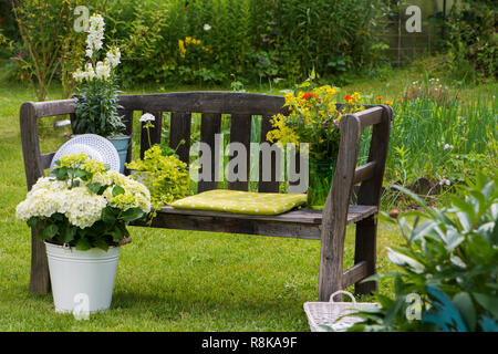 Alte Holz Garten Bank in einem Sommergarten Stockfoto