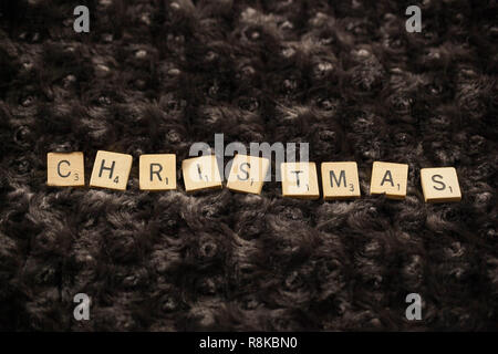 WOODBRIDGE, NEW JERSEY, November 9, 2018: Scrabble Tiles, buchstabieren Sie das Wort Weihnachten auf ein braunes Fell Hintergrund Stockfoto