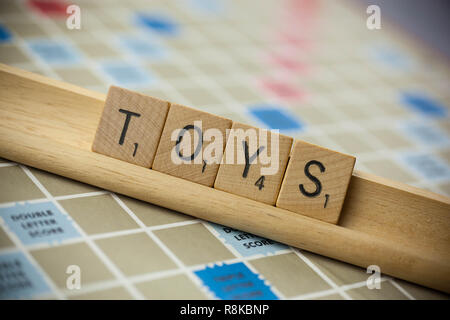 WOODBRIDGE, NEW JERSEY, November 9, 2018: Scrabble Tiles, buchstabieren Sie das Wort Spielzeug auf ein Vintage spiel brett Stockfoto