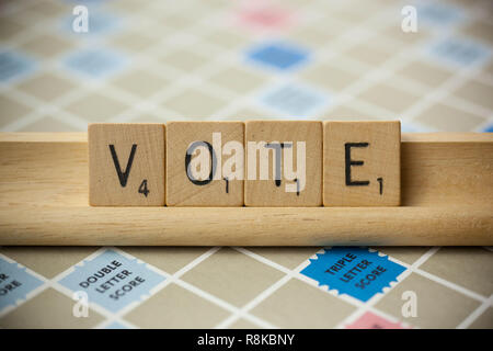 WOODBRIDGE, NEW JERSEY, November 9, 2018: Scrabble Tiles, buchstabieren Sie das Wort Abstimmung über einen Vintage spiel brett Stockfoto