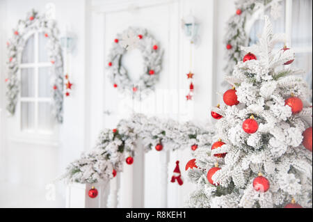 Schöne Frohe Weihnachten und guten Rutsch ins neue Jahr Grußkarte Hintergrund mit schneereichen Winter Haus mit xmas Kranz Stockfoto
