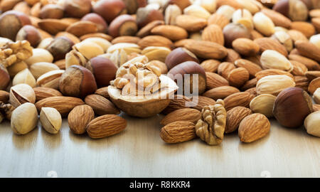 Verschiedene Nüsse Stapel auf einen Holztisch close-up Stockfoto