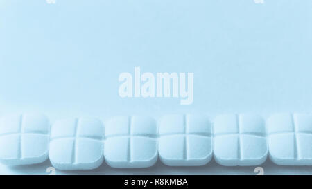 Blick von oben auf die Verschüttete weiße Pillen auf der blauen Fläche Stockfoto